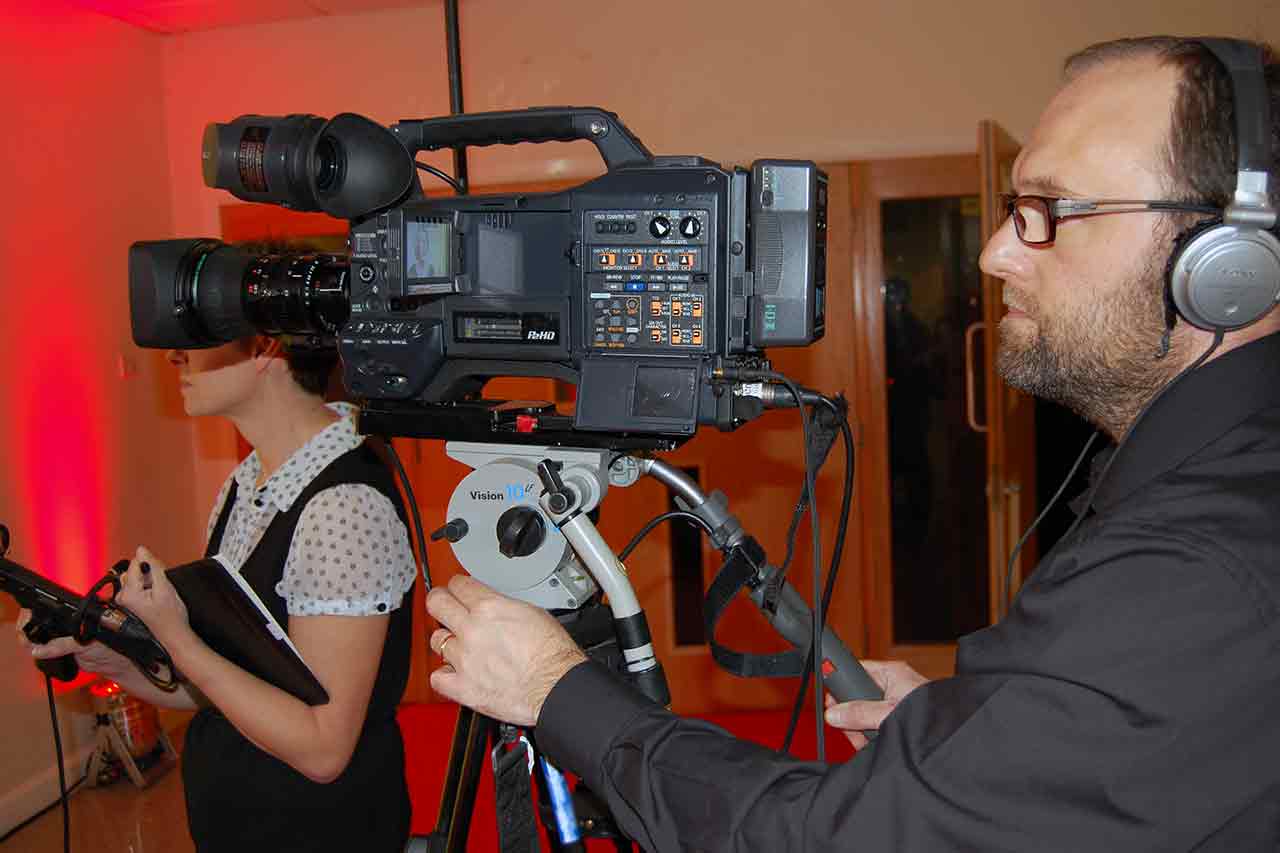 A camera person filming an interview